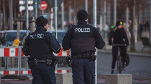 Zwei Polizisten stehen vor einer Baustellenabsperrung